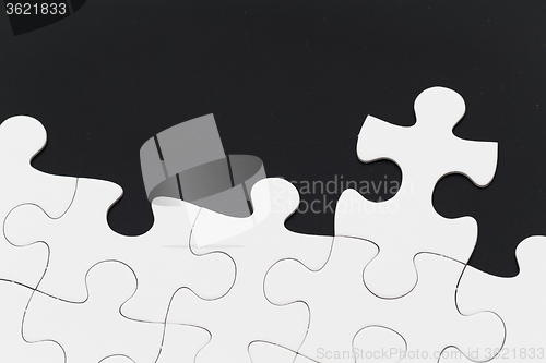 Image of White puzzle over black background