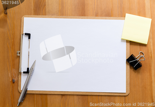 Image of Office desk with clipboard showing a blank paper for advertising