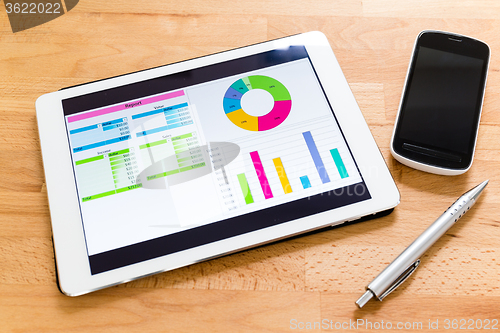 Image of Tablet computer with financial charts on working desk