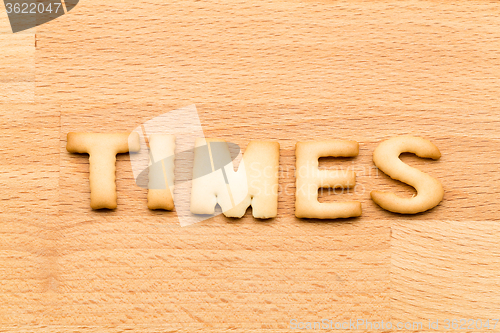 Image of Word times biscuit over the wooden background