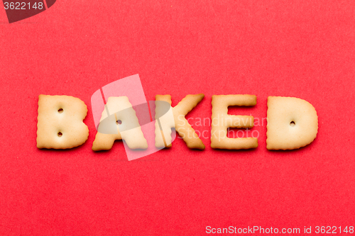 Image of Word baked biscuit over the red background