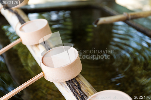 Image of Traditional purification ladles at entrance to Japanese temple