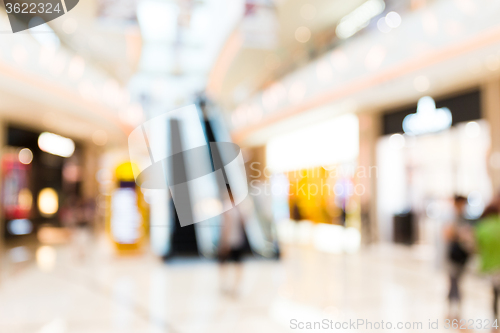 Image of People shopping in department store. Defocused blur background