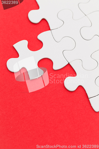 Image of Plain white jigsaw puzzle on Red background