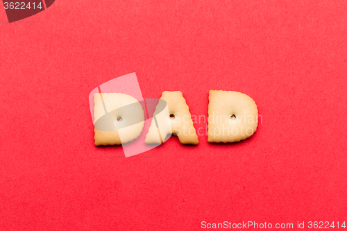 Image of Word dad biscuit over the red background