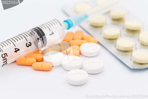 Image of Medication in tablets and capsules and insulin syringe