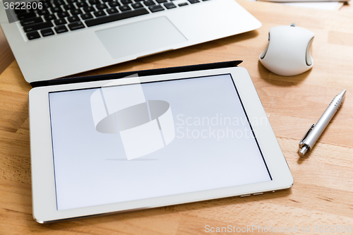 Image of Working desk with mobile phone and digital tablet showing a whit