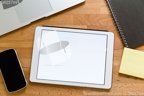 Image of Business working desk with tablet showing a blank screen for adv