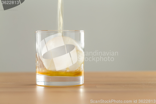 Image of Pouring whiskey drink into glass