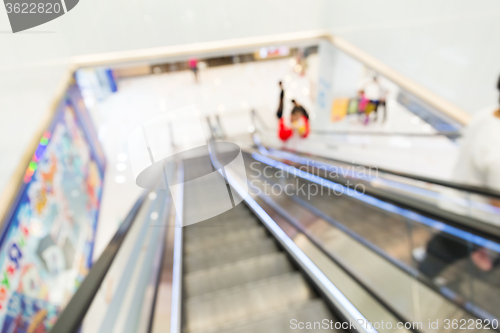 Image of Unfocused view of shopping mall from escalator 