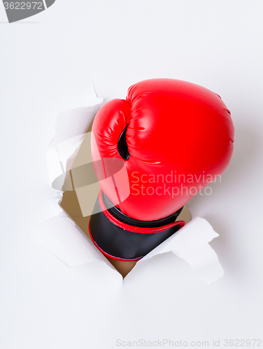 Image of Boxing glove through a hole in paper