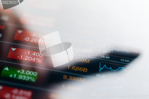 Image of Stock market graph with a shadow of pen