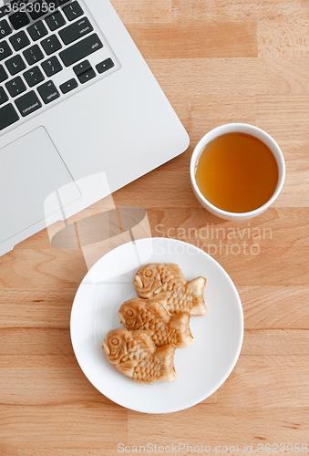 Image of Computer pc with japanese snack and tea