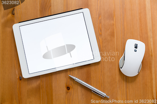 Image of Digital Tablet, pen and mouse on working desk showing a blank sc