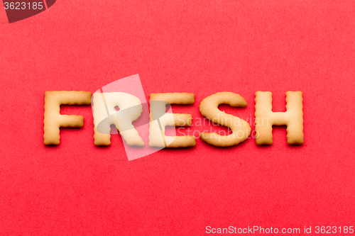 Image of Word fresh cookie over the red background