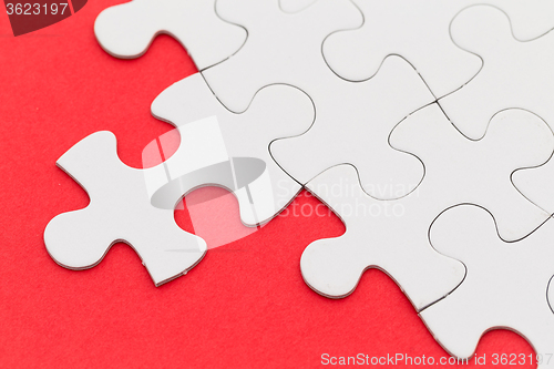 Image of Plain white jigsaw puzzle on red background