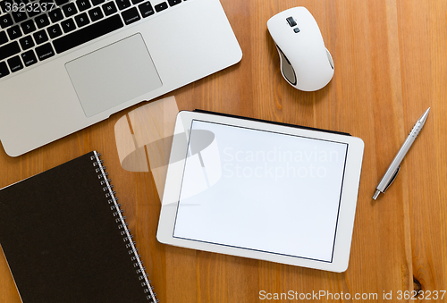 Image of Office table with digital tablet showing a blank screen for adve