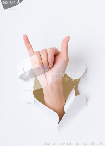 Image of Six finger breaking through paper wall