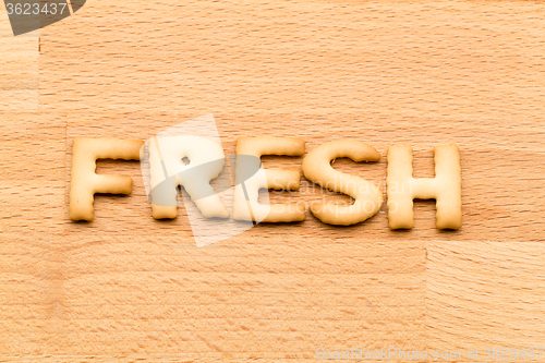Image of Word fresh cookie over the wooden background