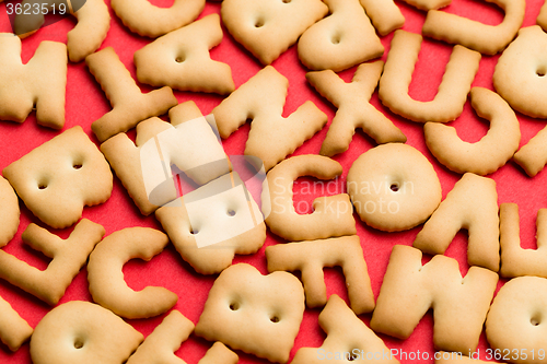 Image of Assorted text biscuit over red background