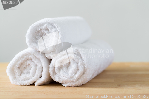 Image of White spa towels pile on wooden table