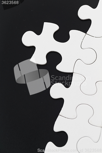 Image of White puzzle over black background