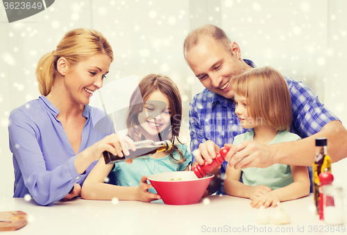 Image of happy family with two kids making salad at home