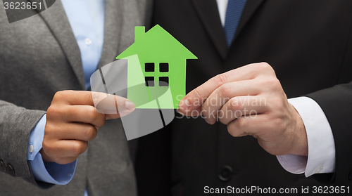 Image of businessman and businesswoman holding green house