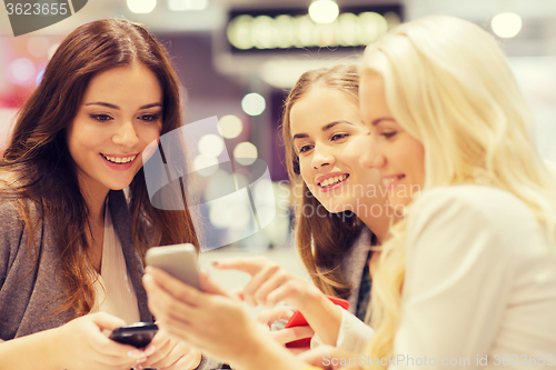 Image of happy women with smartphones and tablet pc in mall