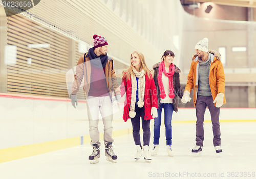 Image of happy friends on skating rink