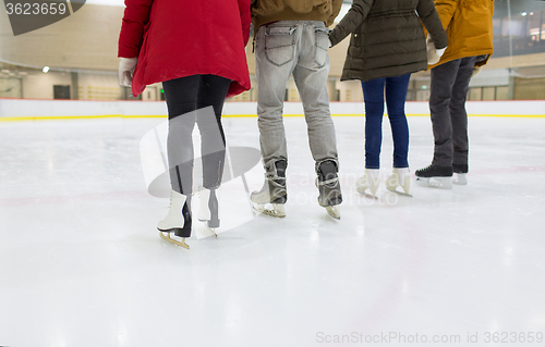Image of close up of happy friends skating on ice rink