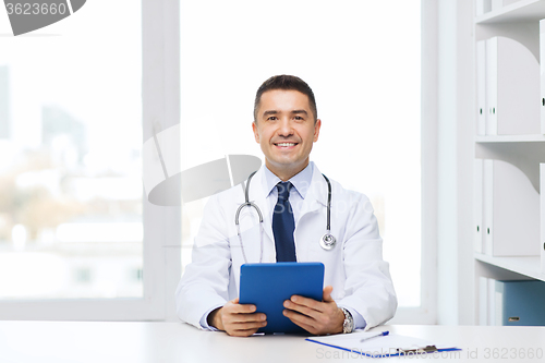 Image of smiling male doctor in white coat with tablet pc