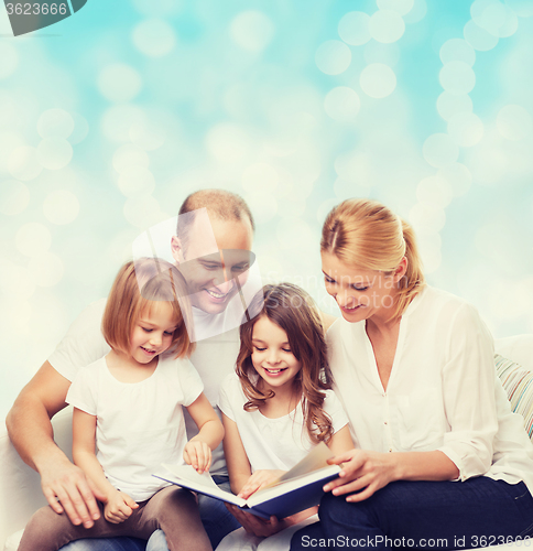 Image of happy family with book at home