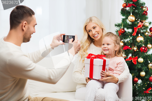 Image of family taking picture with smartphone at christmas