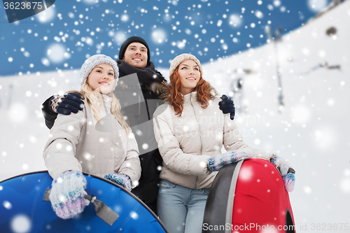 Image of group of smiling friends with snow tubes