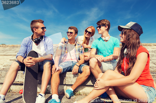 Image of group of smiling friends sitting on city street