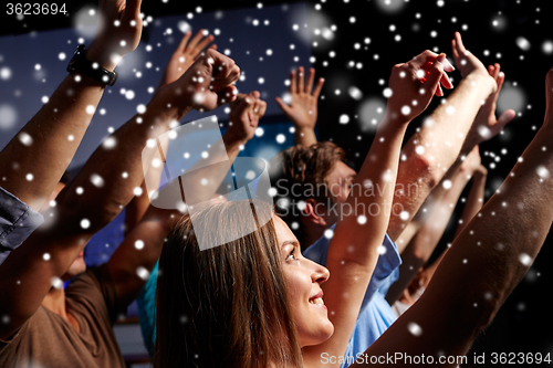 Image of smiling friends at concert in club