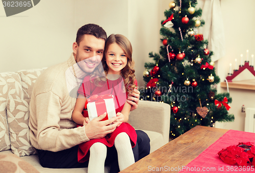 Image of smiling father and daughter holding gift box