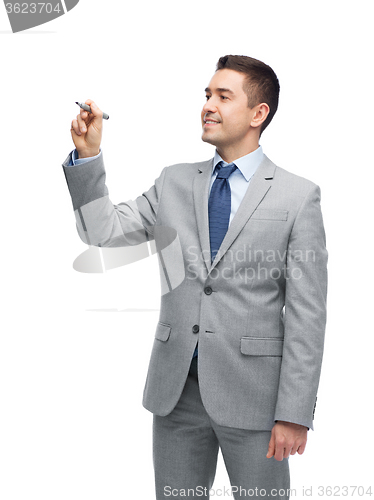 Image of happy businessman in suit writing something