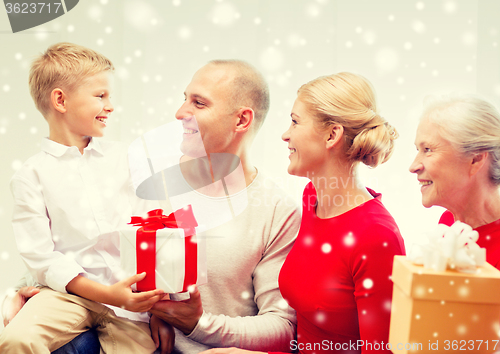 Image of smiling family with gifts at home