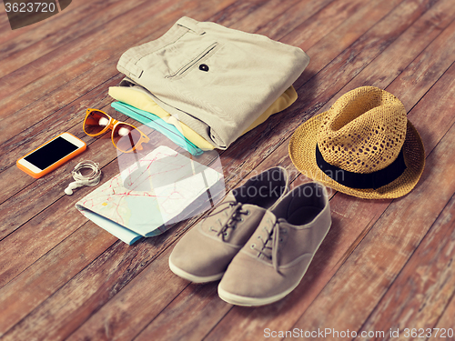 Image of close up of summer clothes and travel map on table