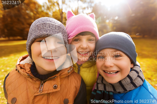 Image of group of happy children hugging in autumn park