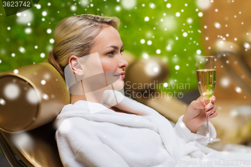 Image of beautiful young woman drinking champagne at spa