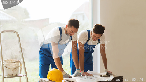 Image of group of builders with blueprint