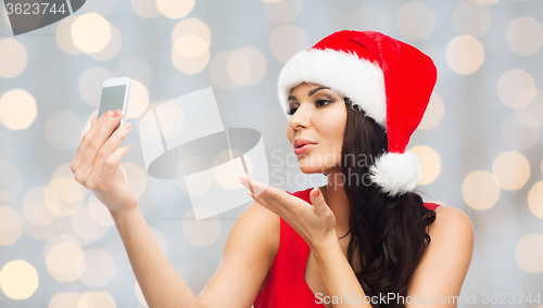 Image of woman in santa hat taking selfie by smartphone