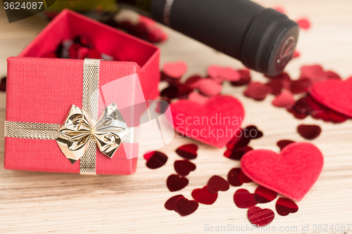 Image of bottle of vine, red hearts and small present