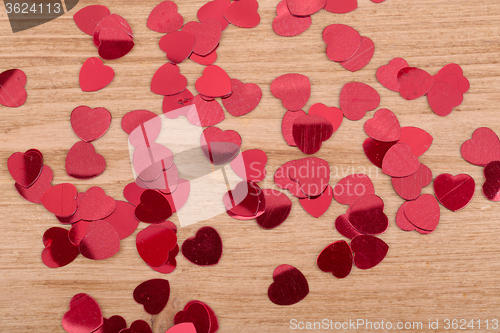 Image of Red hearts confetti on wooden background