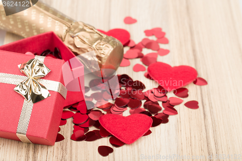 Image of bottle of vine, red hearts and small present