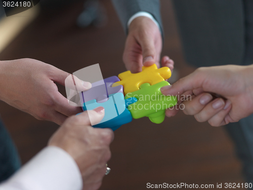 Image of business people group assembling jigsaw puzzle