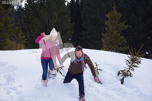 Image of couple having fun and walking in snow shoes